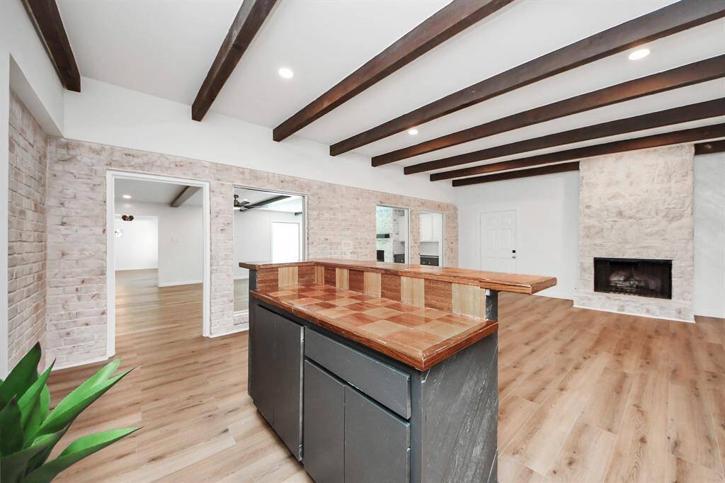 This versatile bonus room offers warm character with exposed brick walls, wood-beamed ceilings, and a cozy stone fireplace. A built-in bar makes it the perfect space for entertaining, game nights, or relaxing with friends and family.