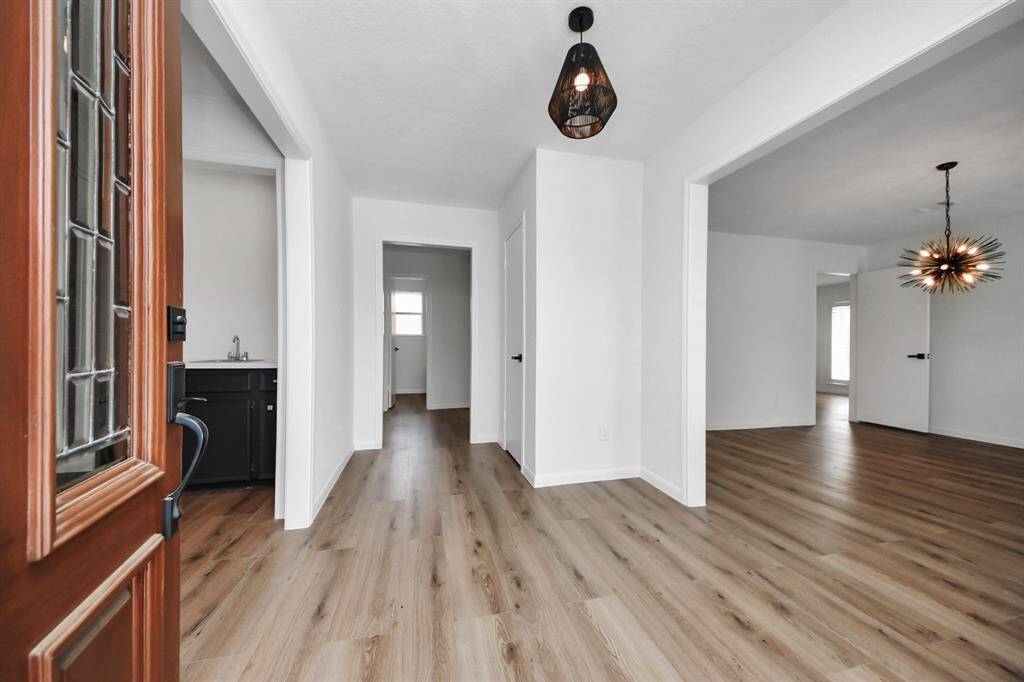 Step inside to a bright and welcoming entryway featuring fresh paint, stylish modern lighting, and wide-plank flooring that flows seamlessly throughout the home.