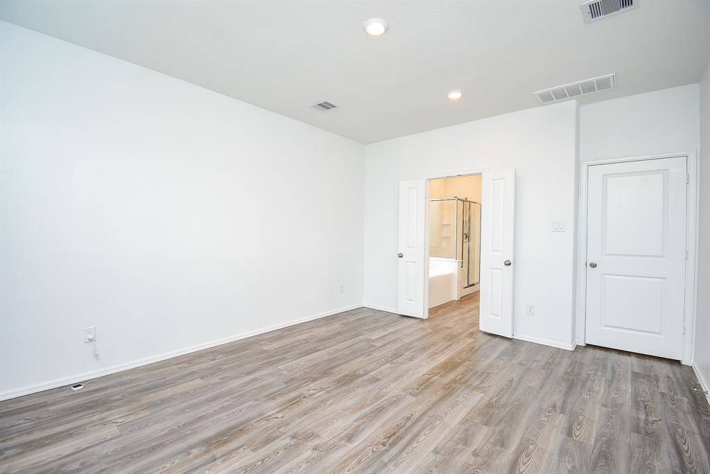 Spacious bedroom accommodates a complete furniture set comfortably.