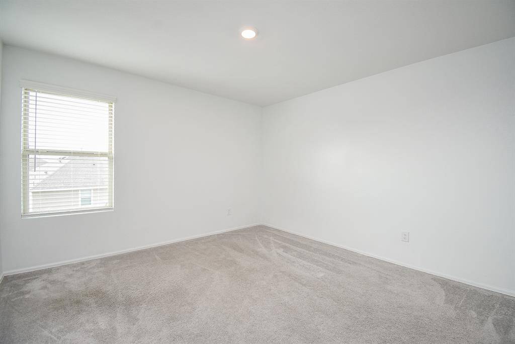 Bright and inviting upstairs third bedroom, perfect for guests or a home office.