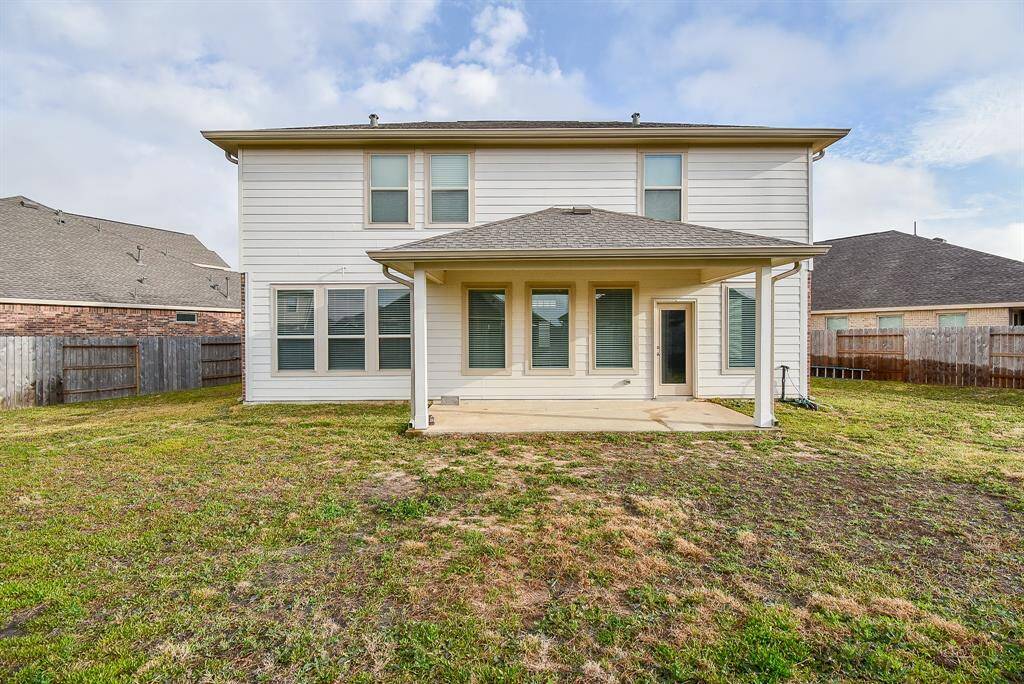 Spacious backyard view with a covered patio, perfect for outdoor gatherings and relaxation.