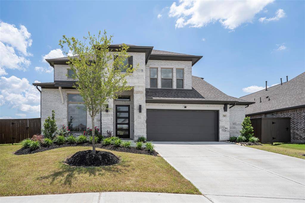 Stunning modern exterior with sleek lines, lush landscaping, and a spacious driveway.