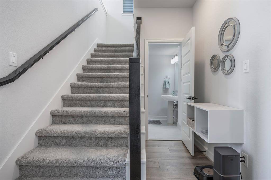 This photo showcases a modern home interior featuring a carpeted staircase leading upward.