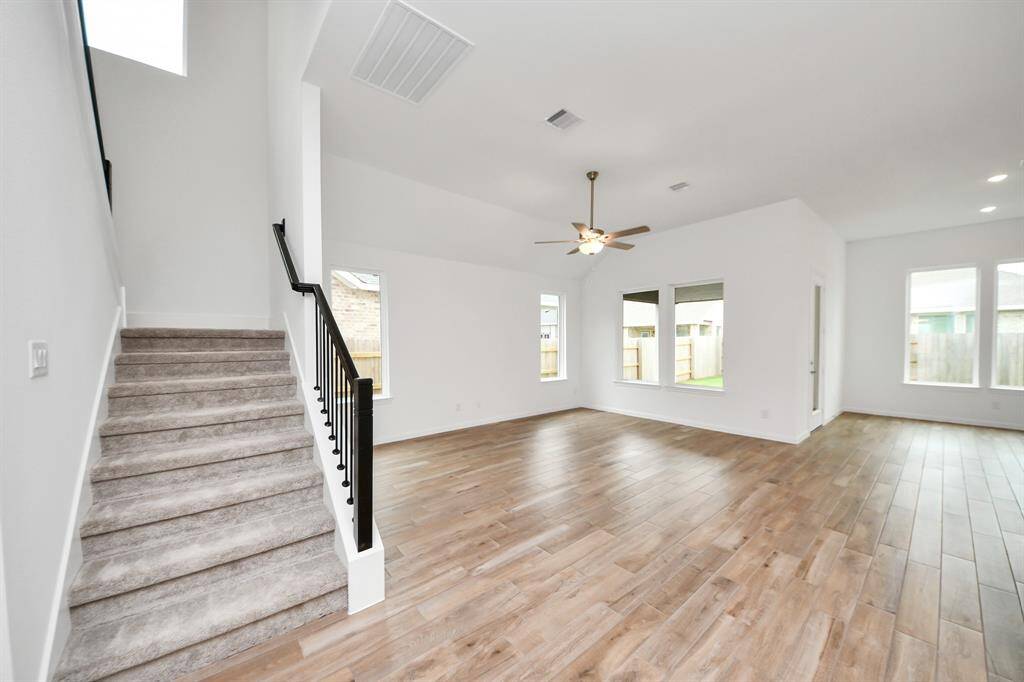 This cozy carpeted room features neutral walls, abundant natural light from the window, and a spacious double-door closet—perfect for a bedroom or office.