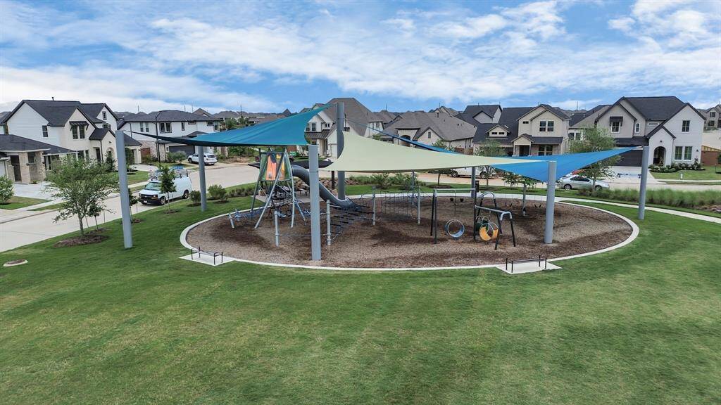 Experience family-friendly living with this inviting playground featuring shade sails, nestled among modern homes and beautifully landscaped lawns.