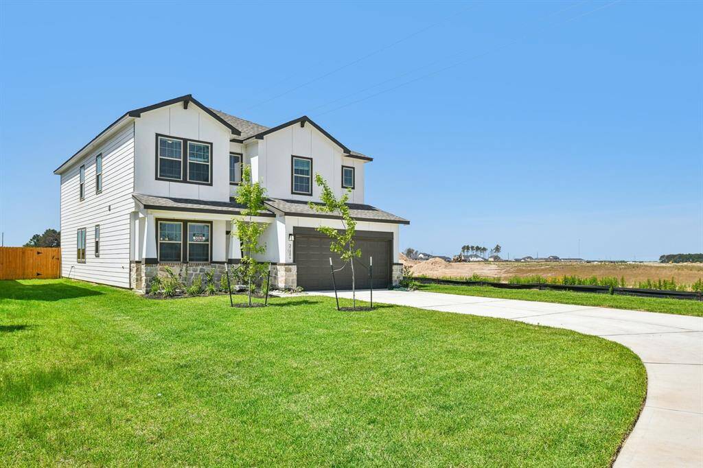 This home boasts a charming design with its crisp siding, striking dark roofline, and an inviting front yard.