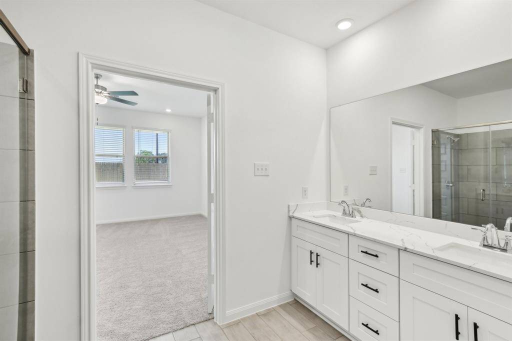 Imagine starting your day at the spacious double vanity, featuring sleek countertops and modern black hardware that adds a touch of sophistication.