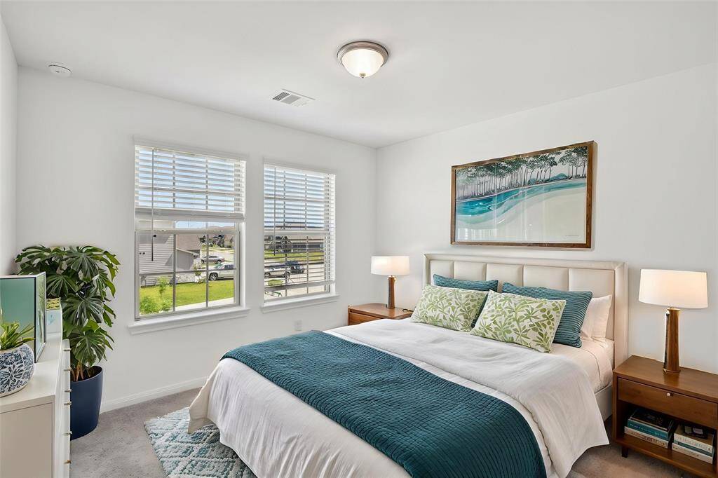 Notice the large windows, clean white walls, and plush carpeting that make this room comfortable and inviting.
