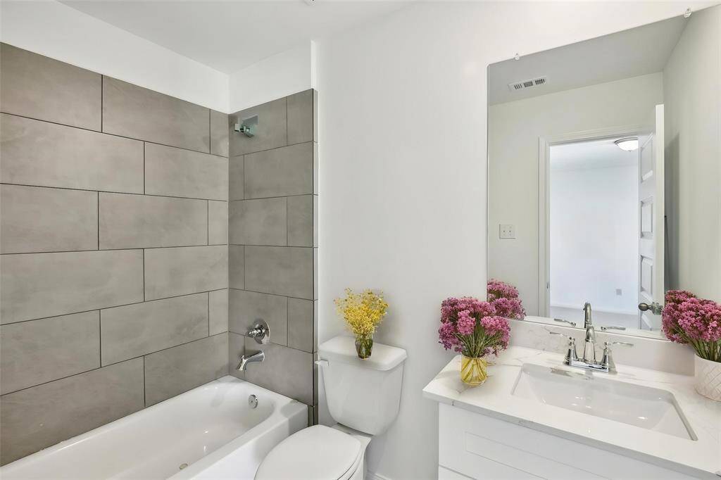This en-suite bath features a shower/tub combination with a beautiful tile wall, and a gorgeous countertop.