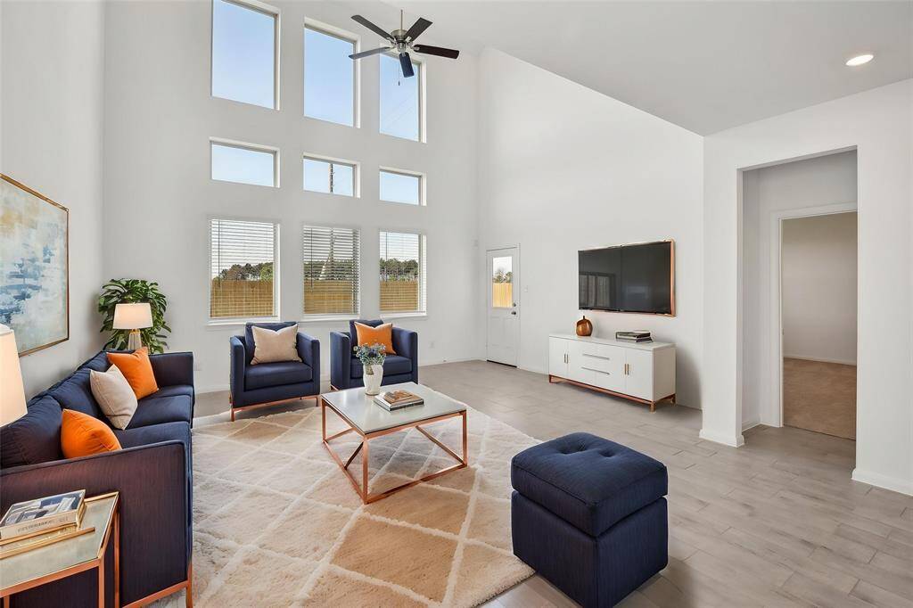 Imagine the soaring ceilings and abundant natural light flooding this impressive living area through the strategically placed windows.