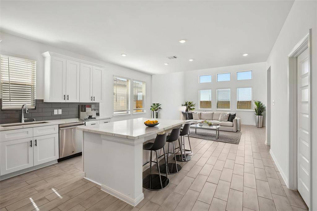 Imagine prepping meals on the expansive center island, featuring a stunning countertop and ample storage.