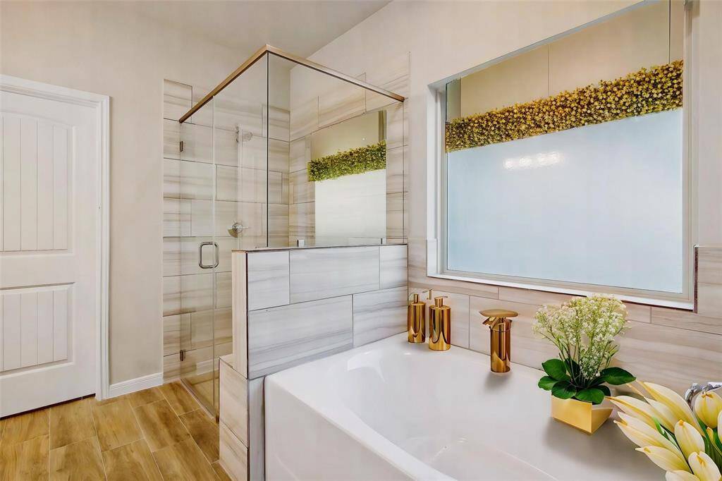 Notice the tile wall in the shower that adds a modern touch. The huge soaking tub right next to the shower offers a relaxing oasis.