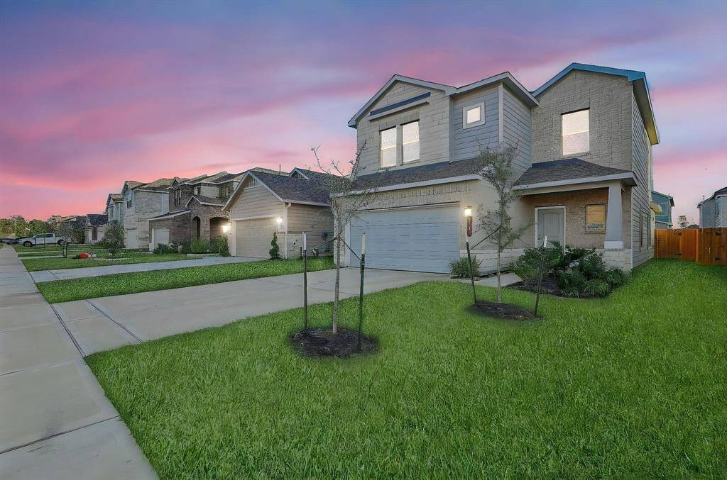 The spacious driveway leads to a two-car garage, providing plenty of parking.