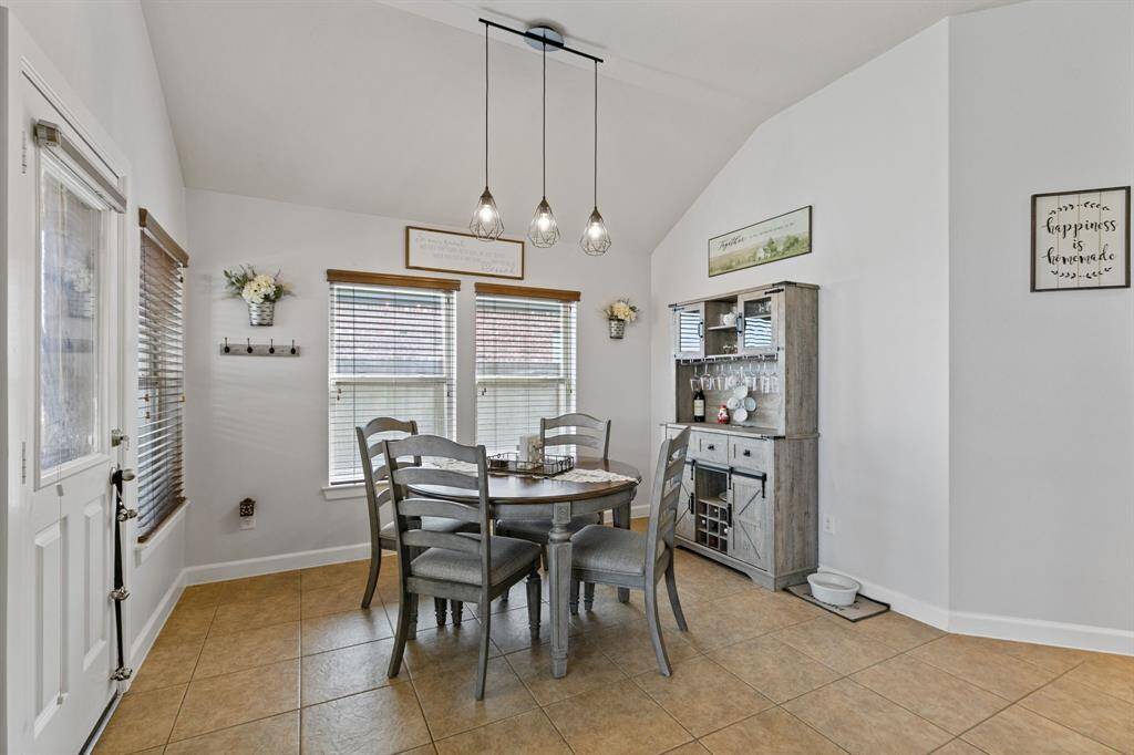 Cozy breakfast nook with charming pendant lights and scenic backyard views.