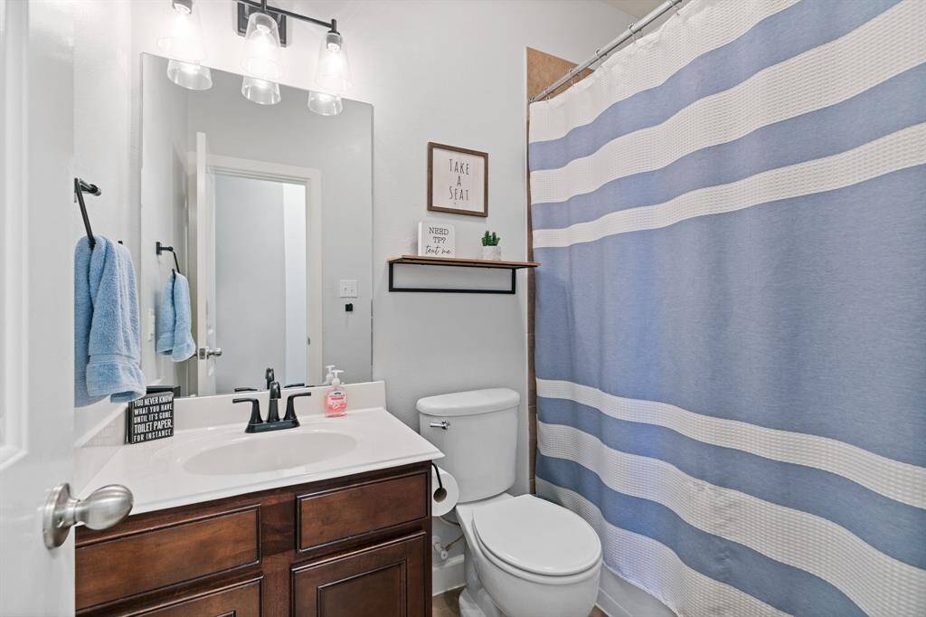 Charming secondary bathroom with elegant lighting and a convenient tub/shower combo.