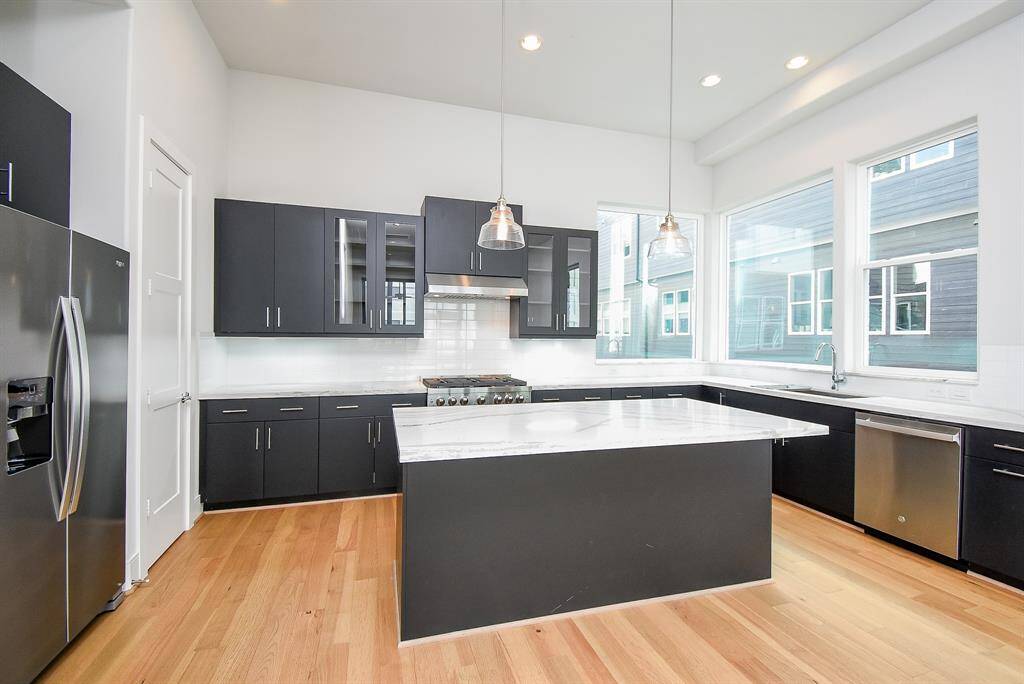 Host your next dinner party with confidence! This masterfully-equipped kitchen features a kitchen island with pendant lighting, an abundance of cabinetry and hardware, TONS of counter space, quartz countertops and stainless-steel appliances.