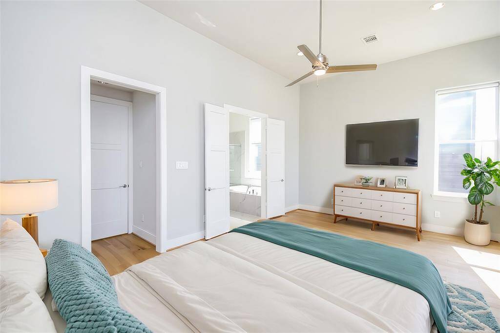 Virtually Staged: Unwind after a long day in this incredible Primary Bedroom! Featuring lots of natural light, hardwood floors, recessed lighting, and a ceiling fan.