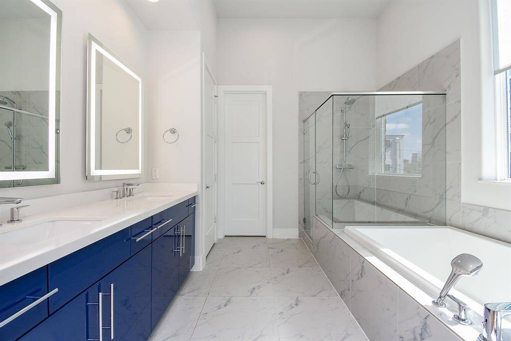 Welcome to your very own retreat! Relax after a long day in this wonderful Primary Bathroom with garden tub, glass enclosed shower, beautiful double sinks, and modern fixtures.