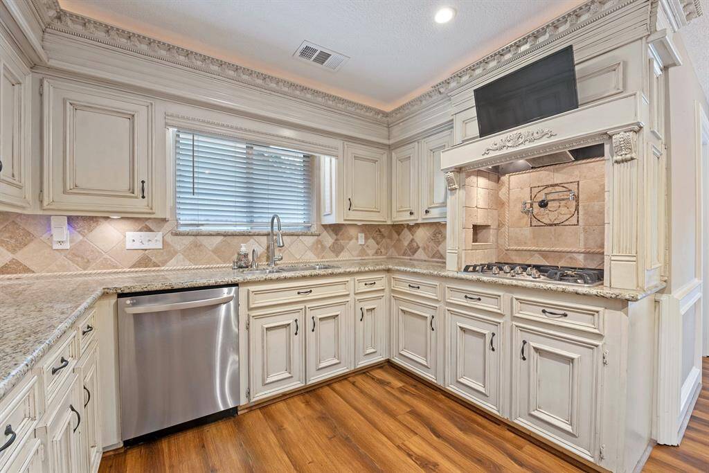 Gas stove with water filler, stainless appliances, and a TV all ready for you to start creating meals here.
