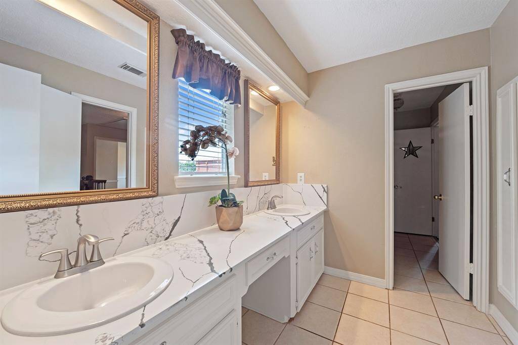 Beautifully updated, the upstairs bath boasts double vanities.
