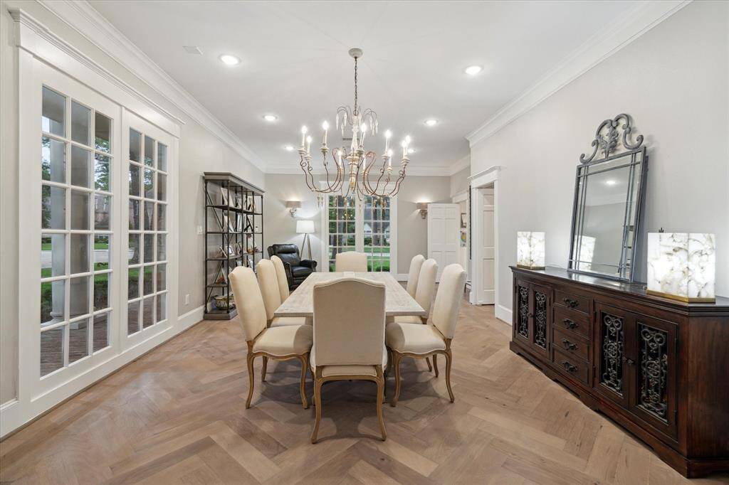Another view of the DINING ROOM with gorgeous chevron-patterned hard wood floors and crown molding.