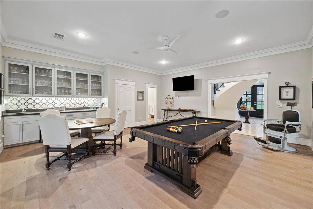 The GAMEROOM just off the entry overlooking the backyard is equipped with a wet bar and lots of counter and cabinet space for easy entertaining. Large storage closet and powder room shown at back.