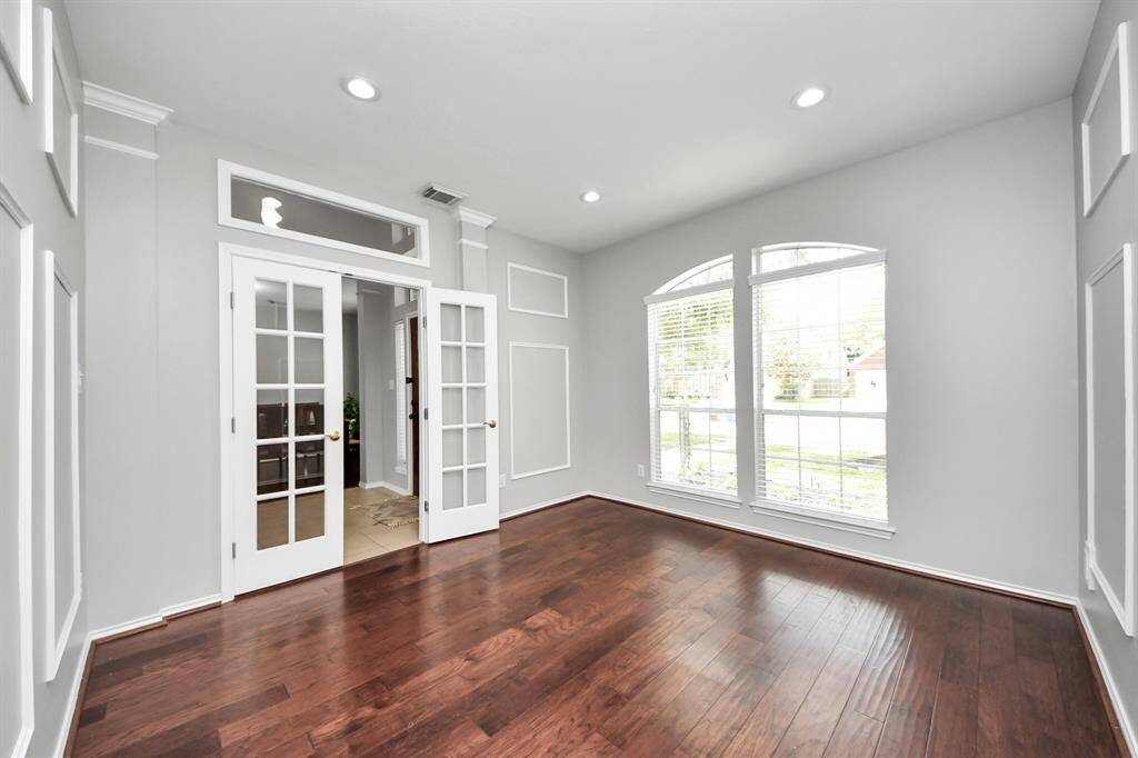 Tucked behind elegant glass French doors, this private, spacious home office offers an ideal retreat for productivity and focus. Large windows flood the room with abundant natural light, creating a bright and uplifting atmosphere.