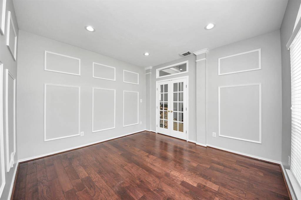 The gleaming wood floors provide a polished, professional look, while the picture frame moldings add a touch of classic charm. Whether you’re working from home or seeking a quiet place for study or creativity, this room provides both function and style in a peaceful, well-lit setting.