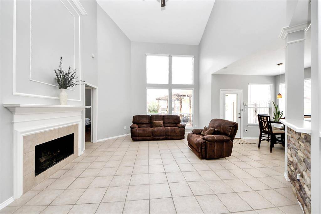 Step into the soaring family room, where vaulted ceilings and an abundance of natural light create a bright, open, and inviting atmosphere.