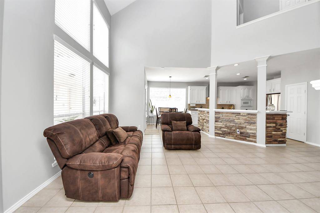 The open floor plan effortlessly connects the family room to the kitchen and breakfast area, enhancing the sense of space and making it ideal for both casual relaxation and vibrant entertaining.