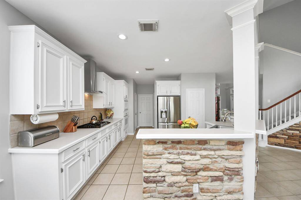 The tile backsplash adds a touch of texture and visual interest, perfectly complementing the sleek surfaces of the counters and cabinetry.
