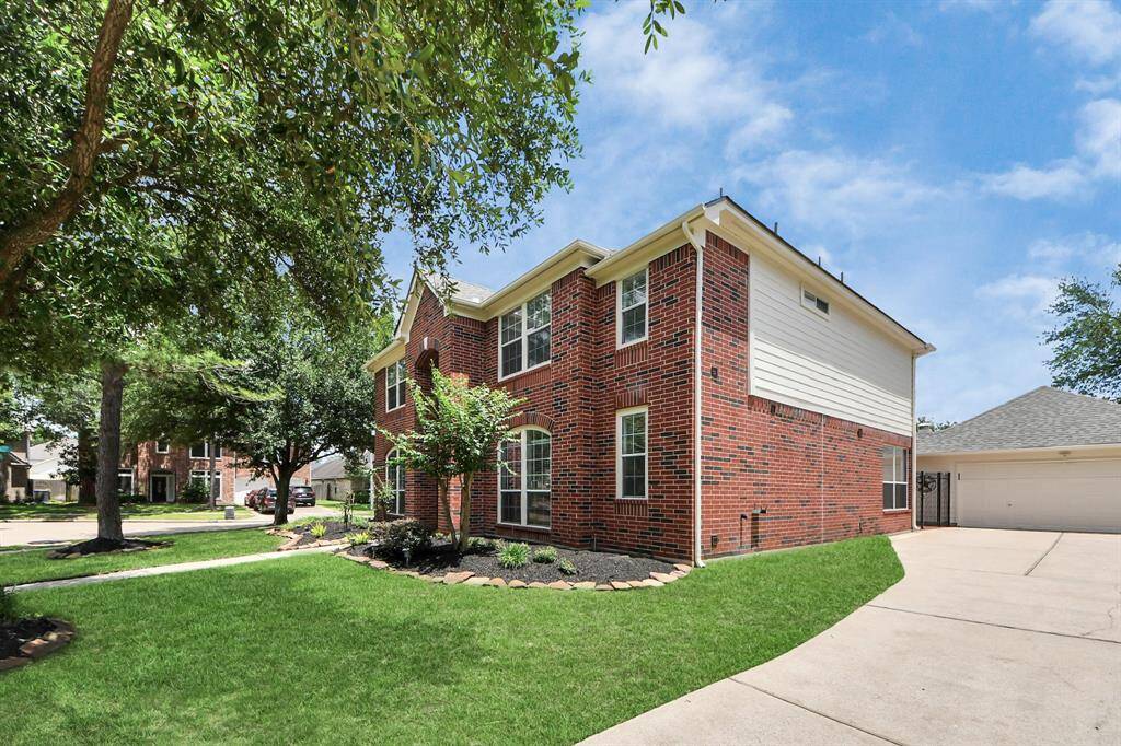 The extended driveway leads to a detached, oversized 2-car garage, providing ample space for parking and storage.