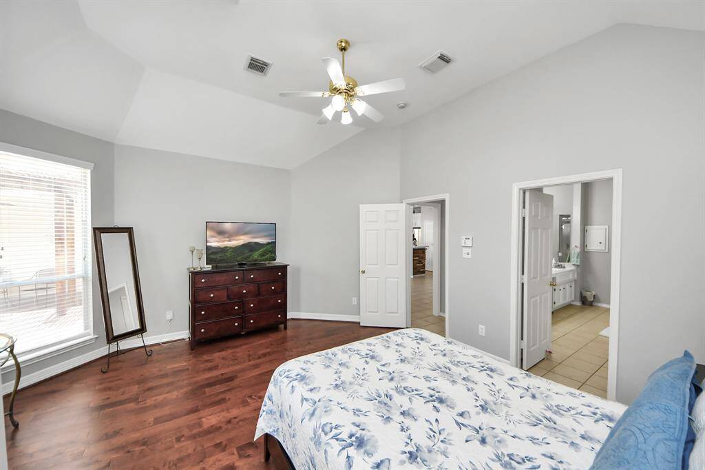 The gleaming wood floors add warmth and elegance, perfectly complementing the room's inviting atmosphere.  The room is also complemented by a private ensuite bathroom, providing a luxurious and peaceful escape.