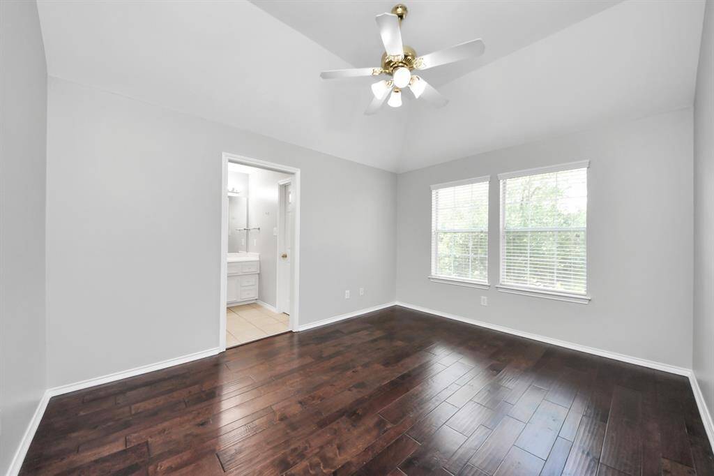 This spacious secondary bedroom, which conveniently shares a Jack and Jill bathroom, offers plenty of room to relax and unwind. Large windows flood the space with natural light, creating a bright and inviting atmosphere.