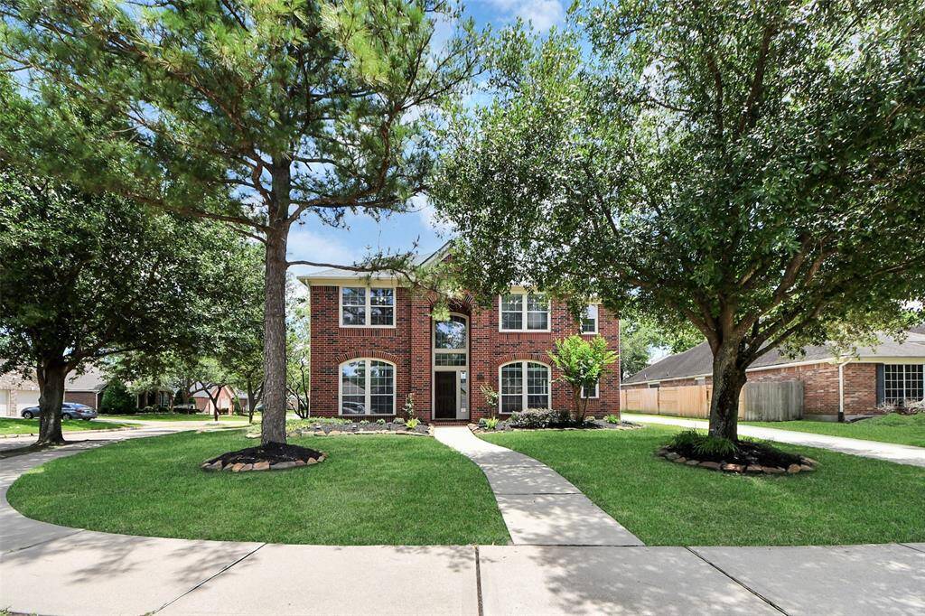Mature trees grace the front corner lot, providing ample shade and enhancing the home’s curb appeal.