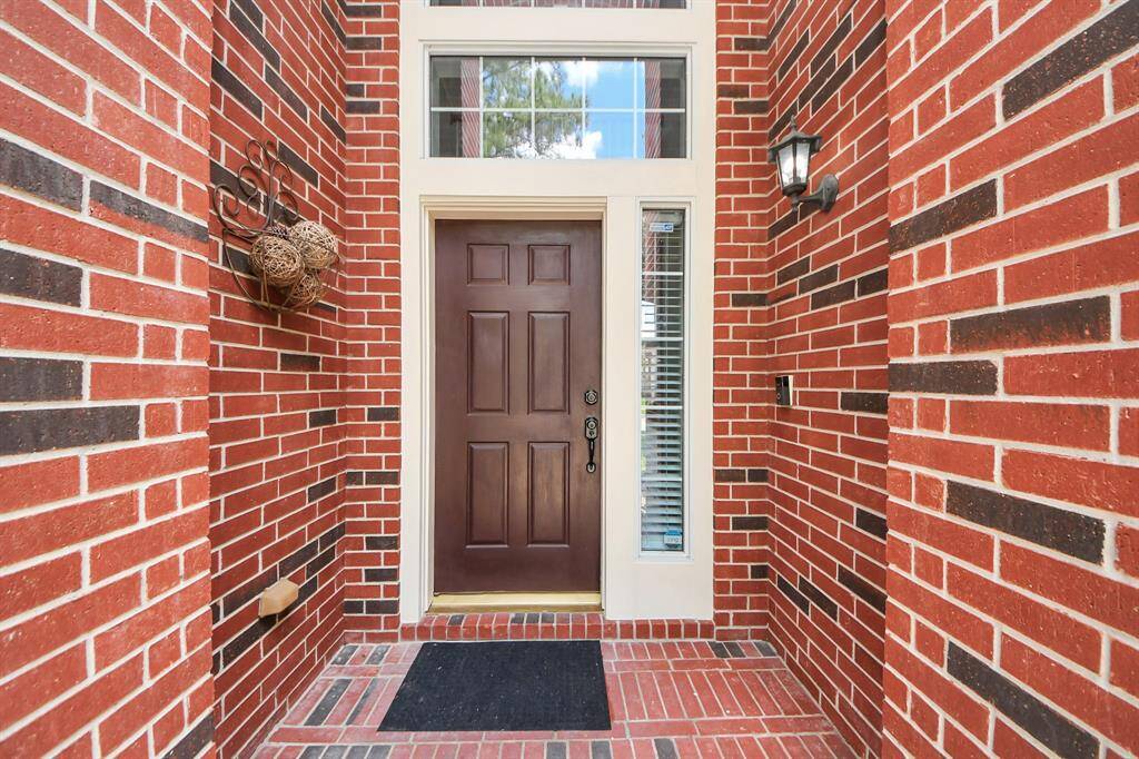A soaring covered entrance invites you to step inside, offering a warm welcome. The solid front door, complemented by a transom window and sidelight windows, allows natural light to spill into the entryway.