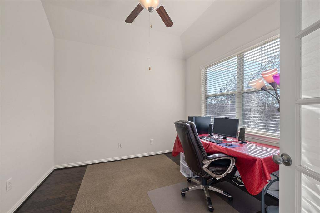 Compact laundry area with stacked washer and dryer, carpeted floor, and a small window providing natural light.