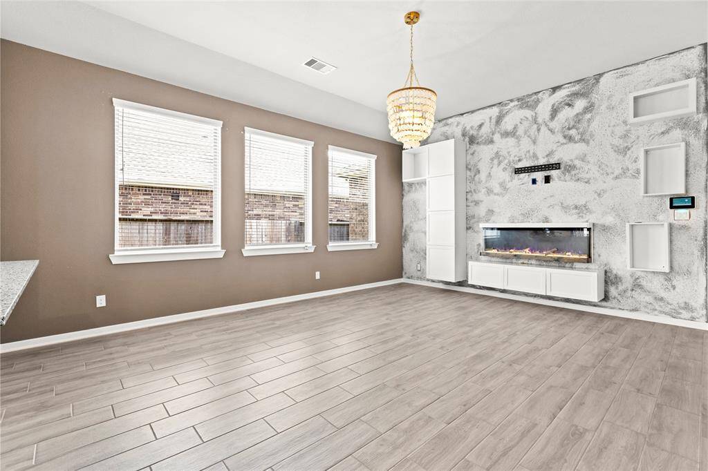 Spacious living room featuring built-in shelving and large, light-filled windows.