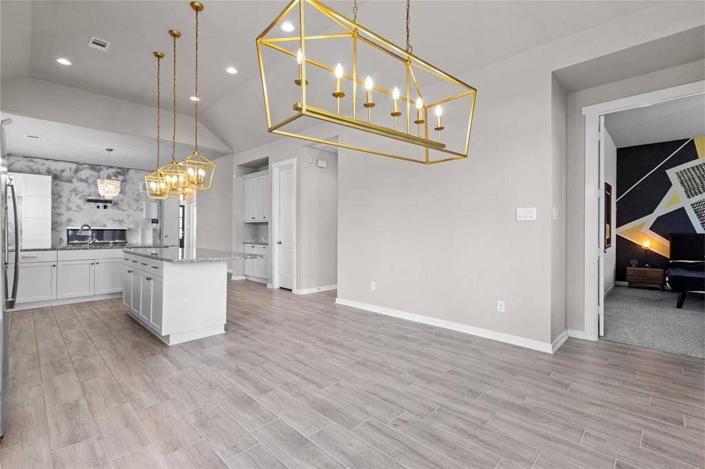 Elegant dining area with modern lighting, open layout, and easy access to the kitchen, perfect for entertaining.