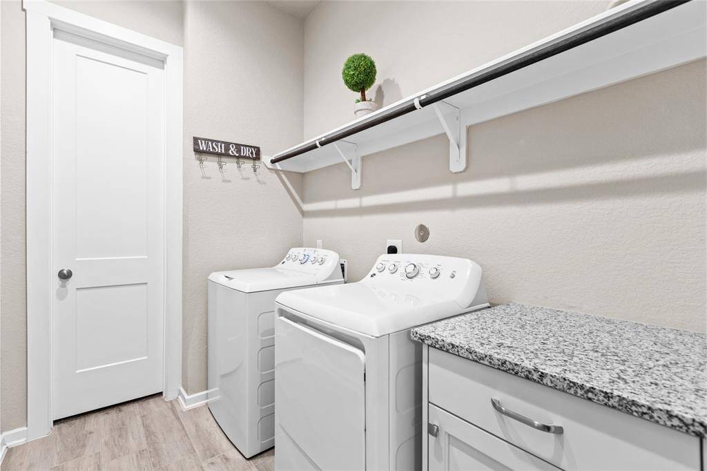 Spacious and efficient laundry room featuring modern appliances, ample countertop space, and convenient shelving for organization. Perfect for easy and enjoyable laundry days.