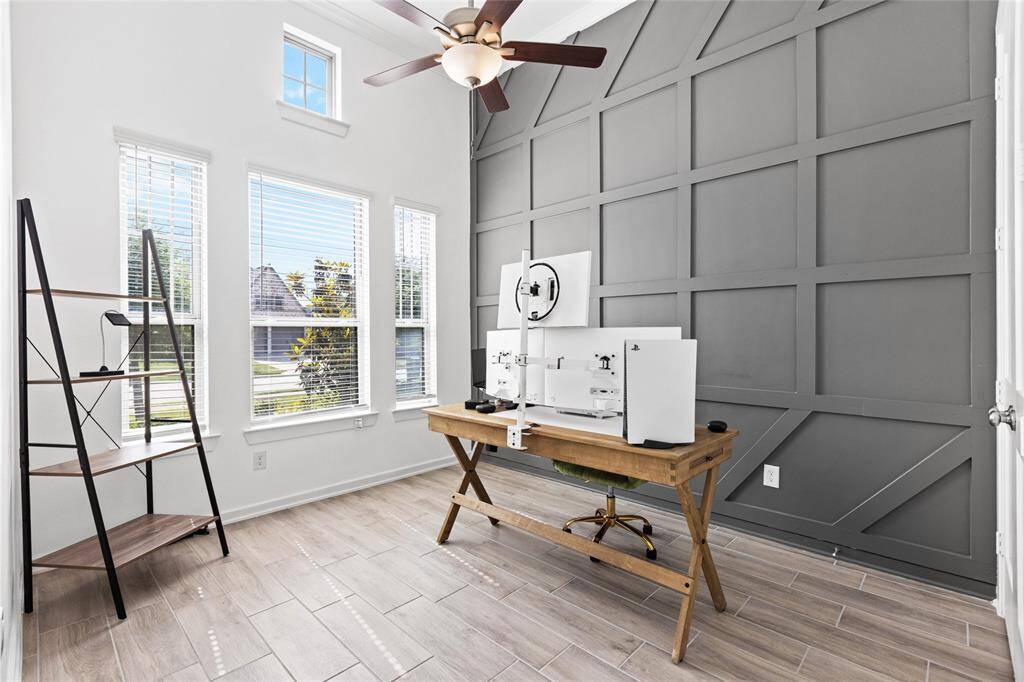Elegant study with built-in shelving and a striking accent wall.