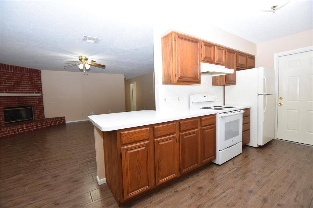 This thoughtfully designed breakfast bar serves as a functional and stylish bridge between the efficient galley kitchen and the inviting living room.