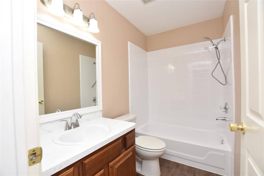 Adjacent to the bedrooms is a thoughtfully designed guest bathroom, complete with a tub/shower combo that caters to various bathing preferences.