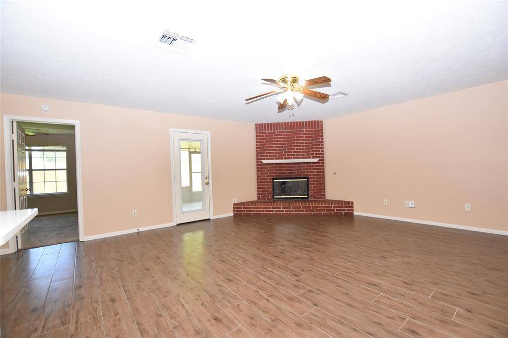 The focal point of the room is a classic red brick gas fireplace, offering warmth and a timeless aesthetic that complements various interior styles.