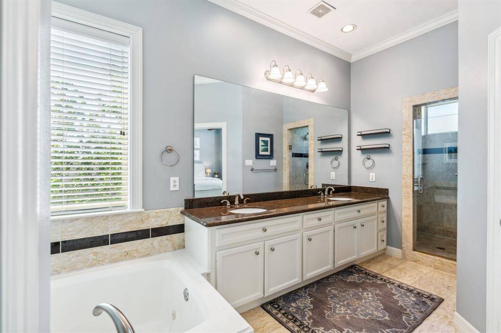 Complete with a jacuzzi tub, separate shower, and a double sinks adorned in granite.