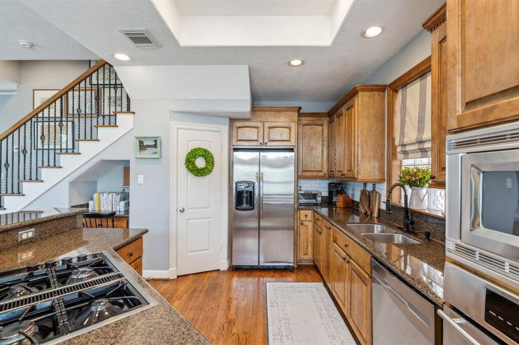 Decked out with stainless steel appliances, including a gas cooktop and wall oven and kitchen sink with a picturesque window overlooking the outdoors.
