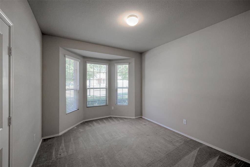 Guest bedroom with double door closet and bay window overlooking the front yard.