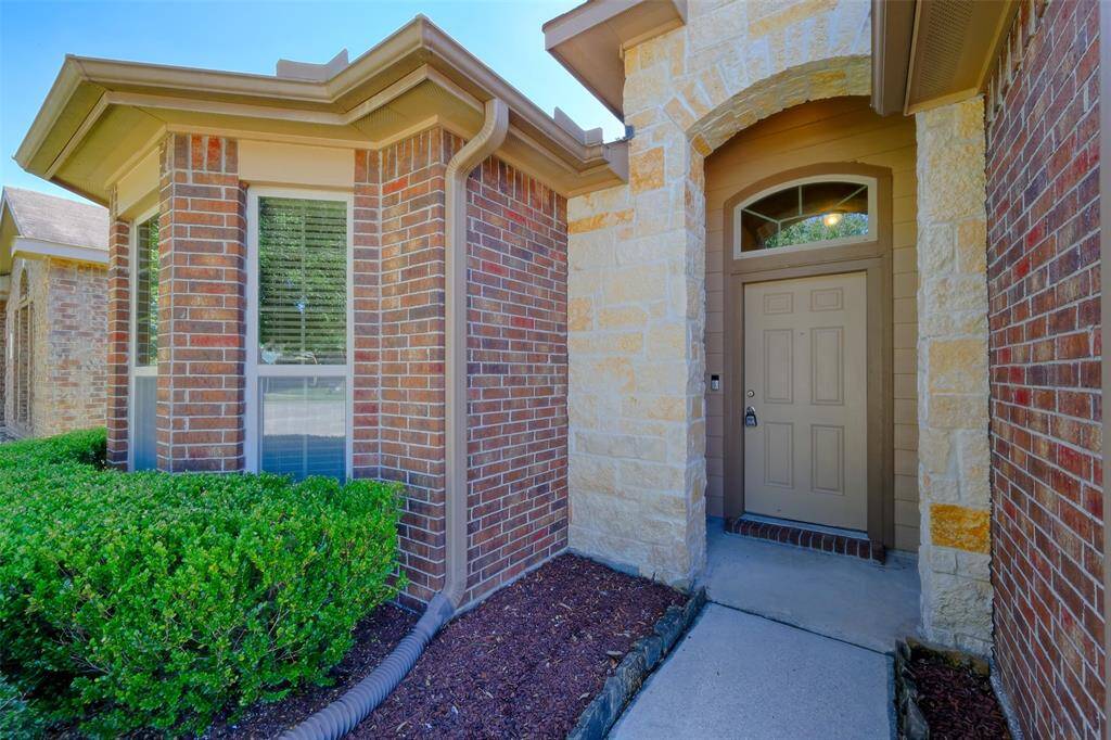 Covered front entry is accented by stone.