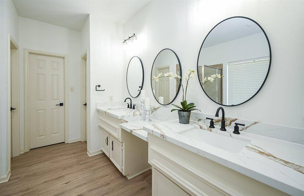 The primary bathroom features dual sinks, vanity area, walk-in shower, and separate tub.
