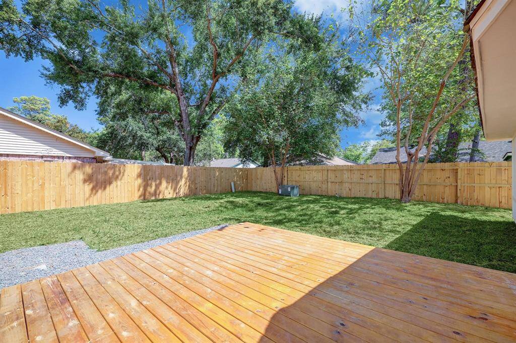 Stretching from the back of the home, the wooden deck provides a setting for al fresco dining or morning coffee, overlooking the private backyard oasis.